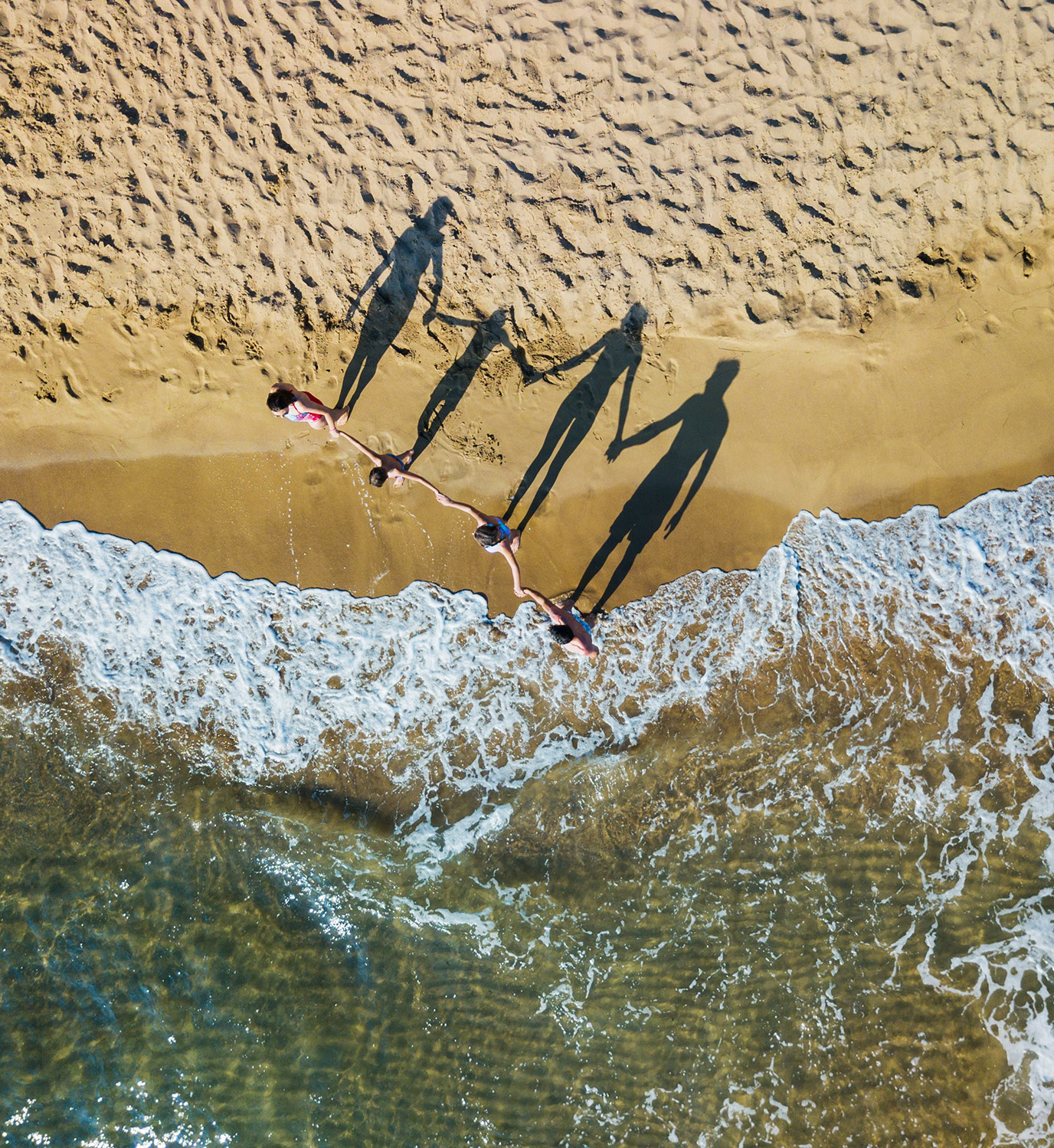 Happy family having fun in the summer leisure. Aerial drone birds eye view photo.